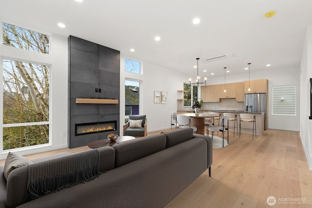 8337 14th Ave NW Unit A, Seattle, WA 98117 - living room with a tile fireplace, recessed lighting, light wood finished floors, a chandelier, and baseboards