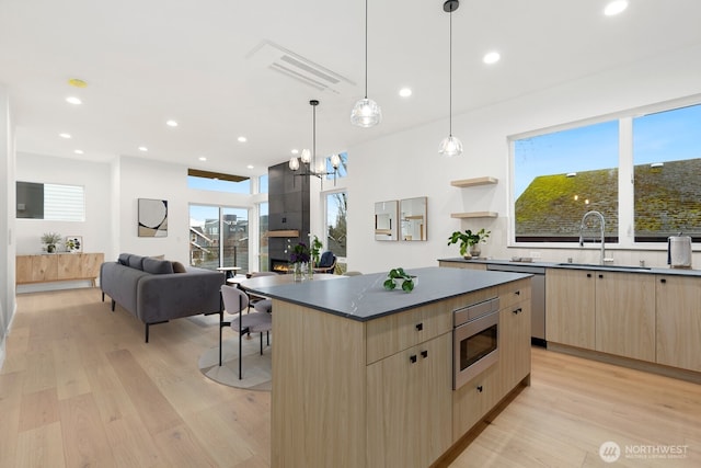 8337 14th Ave NW Unit A, Seattle, WA 98117 - kitchen featuring light brown cabinetry, modern cabinets, a sink, light wood-style floors, and dark countertops