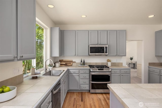 23600 Dunbar Pl NW, Poulsbo, WA 98370 - kitchen with stainless steel appliances, gray cabinetry, tile counters, and recessed lighting