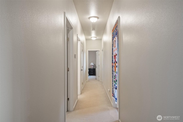 14647 NW Honeyhill Loop, Seabeck, WA 98380 - hall featuring light colored carpet, baseboards, and a textured wall