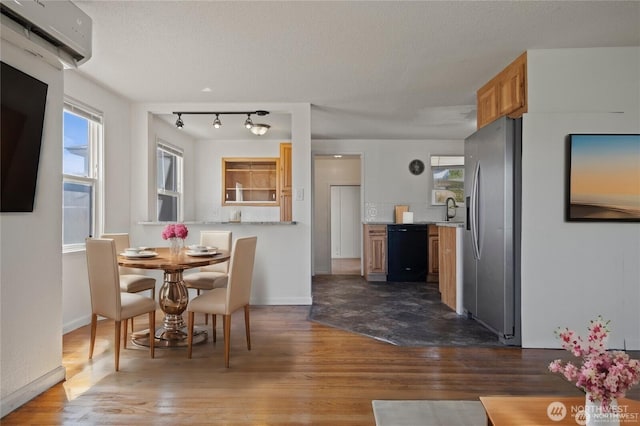 177 E St SE, Ephrata, WA 98823 - dining room with a wall unit AC, dark wood-style floors, baseboards, and a textured ceiling
