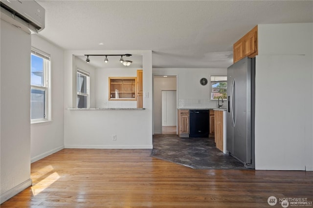 177 E St SE, Ephrata, WA 98823 - kitchen with dishwasher, a wall mounted AC, stainless steel refrigerator with ice dispenser, dark wood-style floors, and a textured ceiling