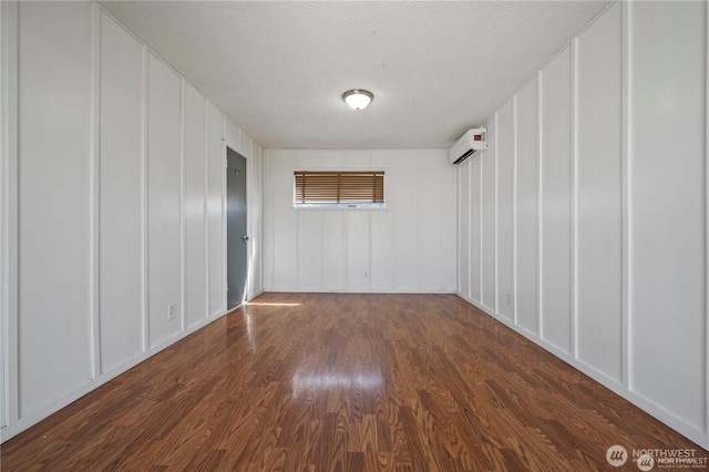 177 E St SE, Ephrata, WA 98823 - spare room with a decorative wall, a wall mounted AC, and dark wood-style floors