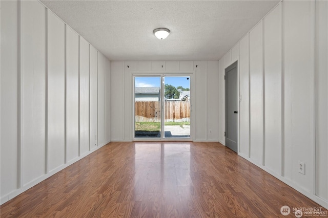 177 E St SE, Ephrata, WA 98823 - empty room featuring a decorative wall, wood finished floors, a textured ceiling, and baseboards