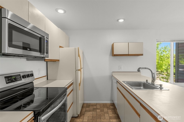 10329 Meridian Ave N Unit A201, Seattle, WA 98133 - kitchen with stainless steel appliances, a sink, light countertops, baseboards, and recessed lighting