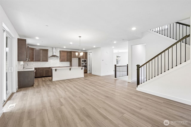 15612 210th Ave E Unit 313, Bonney Lake, WA 98391 - unfurnished living room featuring a sink, light wood-type flooring, a chandelier, recessed lighting, and baseboards