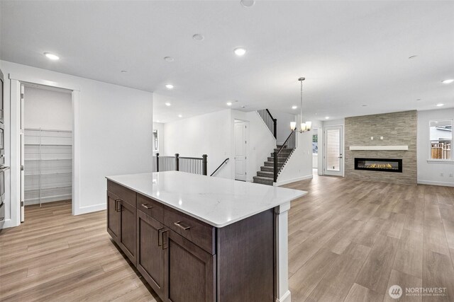 15612 210th Ave E Unit 313, Bonney Lake, WA 98391 - kitchen featuring light wood-type flooring, baseboards, recessed lighting, dark brown cabinets, and a kitchen island