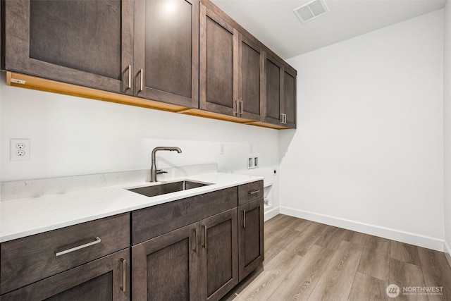 15612 210th Ave E Unit 313, Bonney Lake, WA 98391 - laundry area featuring cabinet space, hookup for a washing machine, electric dryer hookup, light wood-type flooring, and baseboards