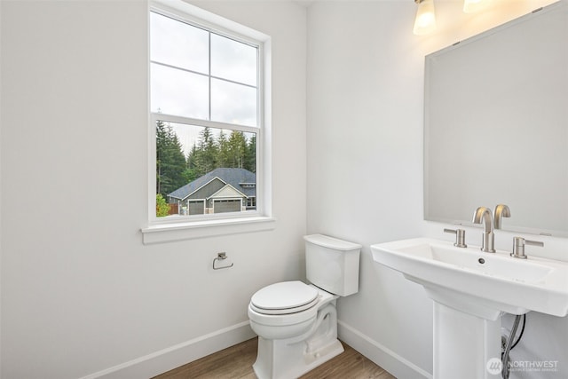 15612 210th Ave E Unit 313, Bonney Lake, WA 98391 - half bathroom with baseboards, wood finished floors, toilet, and a sink