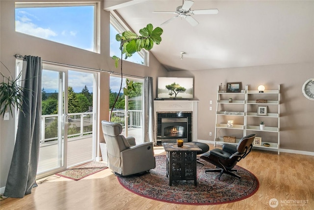 1402 E Lake Dr, Bremerton, WA 98312 - living area featuring a glass covered fireplace, wood finished floors, ceiling fan, high vaulted ceiling, and baseboards