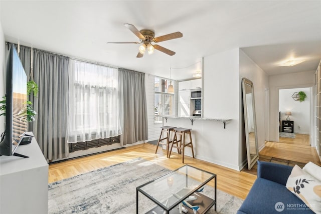 22 John St Unit 10, Seattle, WA 98109 - living room featuring ceiling fan, wood finished floors, and baseboards