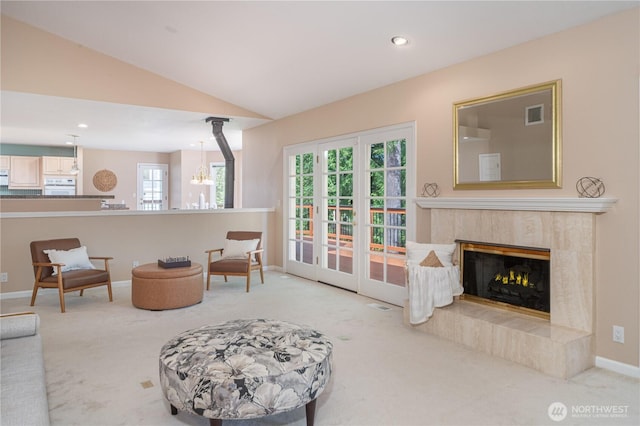 211 Greenview Ln, Port Ludlow, WA 98365 - carpeted living area featuring a chandelier, baseboards, vaulted ceiling, healthy amount of natural light, and a tiled fireplace