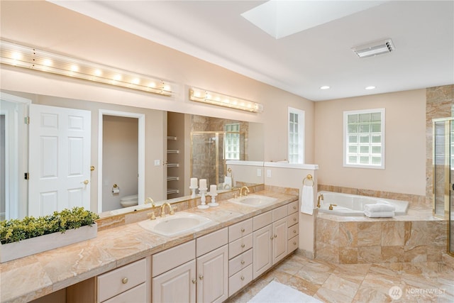 211 Greenview Ln, Port Ludlow, WA 98365 - bathroom with a stall shower, toilet, a bath, a skylight, and double vanity