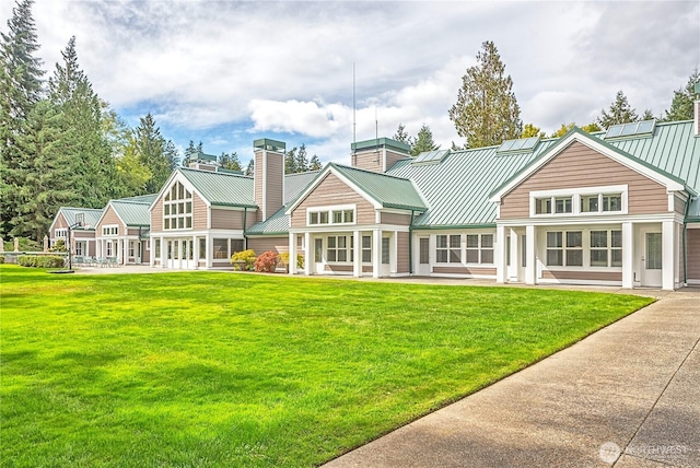 211 Greenview Ln, Port Ludlow, WA 98365 - back of property featuring a chimney, metal roof, a yard, and a standing seam roof