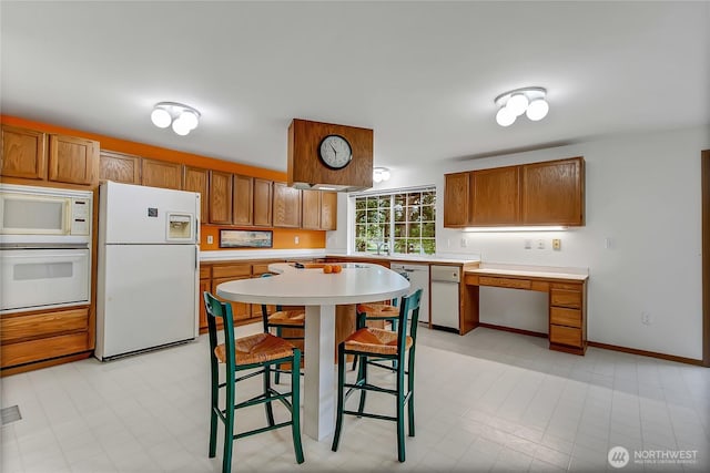 4716 266th St E, Spanaway, WA 98387 - kitchen with white appliances, brown cabinets, and light countertops