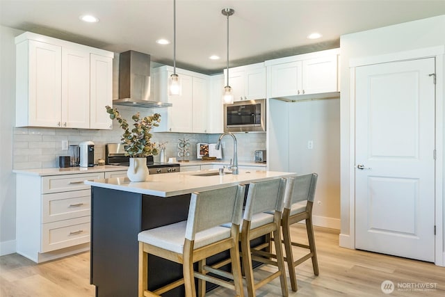 4208 W Sandy Ct, Moses Lake, WA 98837 - kitchen featuring wall chimney range hood, stove, stainless steel microwave, light wood-type flooring, and recessed lighting