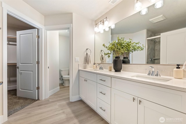 4208 W Sandy Ct, Moses Lake, WA 98837 - bathroom featuring double vanity, a stall shower, and wood finished floors