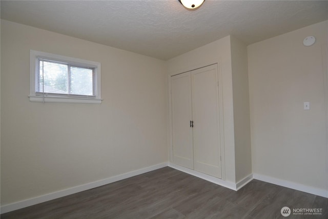 3159 Florida St, Longview, WA 98632 - unfurnished bedroom with dark wood-type flooring, a closet, baseboards, and a textured ceiling