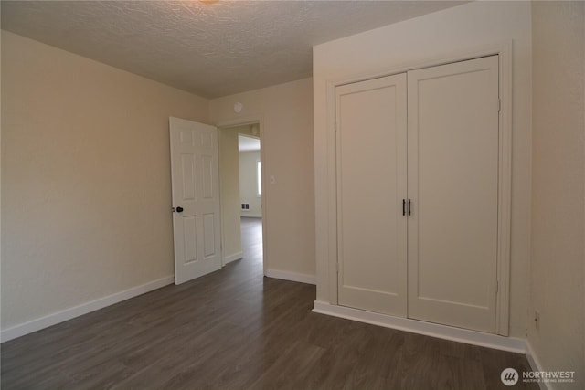 3159 Florida St, Longview, WA 98632 - unfurnished bedroom featuring dark wood-style floors, a textured ceiling, baseboards, and a closet