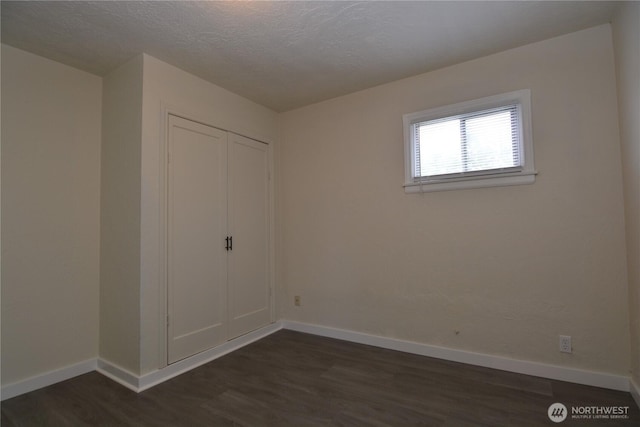 3159 Florida St, Longview, WA 98632 - unfurnished bedroom with baseboards, dark wood-style flooring, a closet, and a textured ceiling