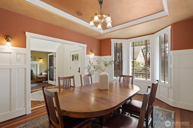 27 148th Pl SW, Lynnwood, WA 98087 - dining space with dark wood finished floors, a chandelier, a tray ceiling, and a wainscoted wall