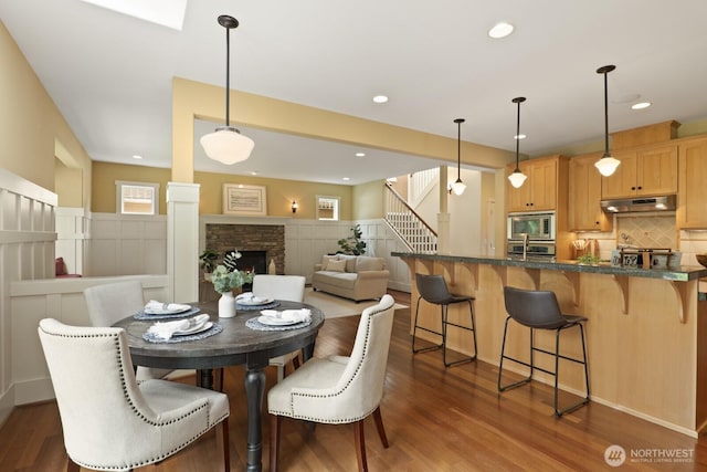27 148th Pl SW, Lynnwood, WA 98087 - dining space featuring dark wood-style floors, stairs, a stone fireplace, and recessed lighting