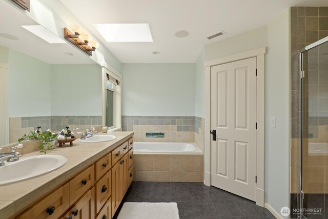 27 148th Pl SW, Lynnwood, WA 98087 - full bathroom featuring a skylight, double vanity, a bath, a shower stall, and tile patterned flooring