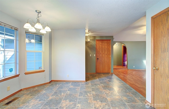 10010 NE 76th Cir, Vancouver, WA 98662 - unfurnished room featuring arched walkways, stone finish floors, a chandelier, and a textured ceiling
