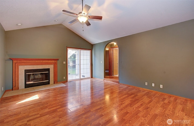 10010 NE 76th Cir, Vancouver, WA 98662 - unfurnished living room featuring arched walkways, ceiling fan, a tile fireplace, wood finished floors, and high vaulted ceiling