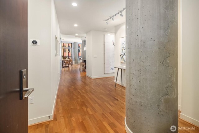2033 2nd Ave Unit 703, Seattle, WA 98121 - corridor featuring wood finished floors, baseboards, recessed lighting, and rail lighting
