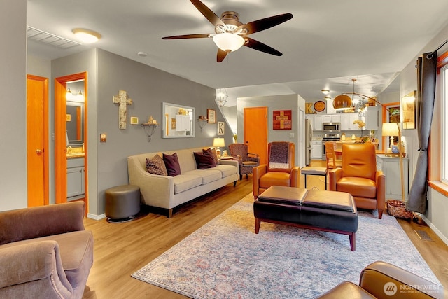 4421 166th Ave E, Lake Tapps, WA 98391 - living area featuring light wood finished floors, a ceiling fan, a chandelier, and baseboards
