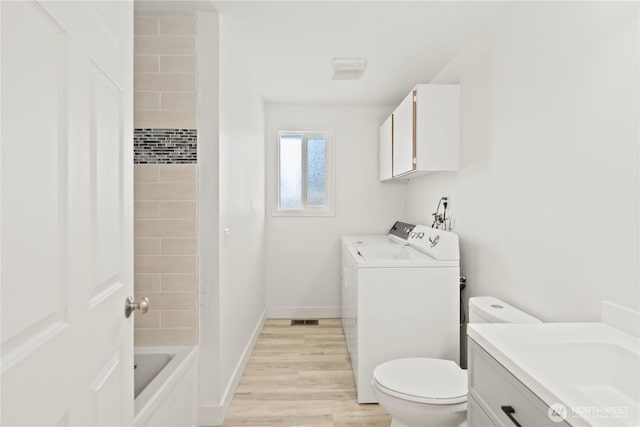 26908 NE Stewart St, Duvall, WA 98019 - full bath with washer and dryer, vanity, toilet, wood finished floors, and tub / shower combination