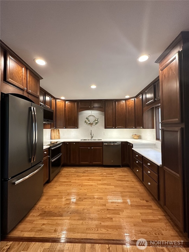 1360 Colchester Dr SE, Port Orchard, WA 98366 - kitchen featuring appliances with stainless steel finishes, a sink, light countertops, dark brown cabinets, and light wood-style floors