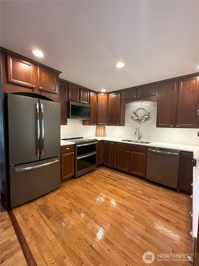 1360 Colchester Dr SE, Port Orchard, WA 98366 - kitchen featuring appliances with stainless steel finishes, a sink, light countertops, light wood-type flooring, and recessed lighting