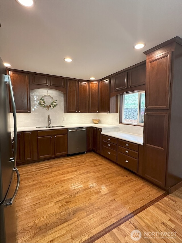 1360 Colchester Dr SE, Port Orchard, WA 98366 - kitchen with stainless steel appliances, a sink, light countertops, dark brown cabinetry, and backsplash