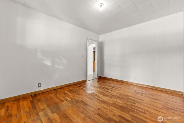 318 Lombard St, Twisp, WA 98856 - spare room featuring arched walkways, wood-type flooring, and baseboards