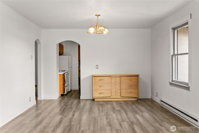 318 Lombard St, Twisp, WA 98856 - unfurnished room with baseboard heating, arched walkways, light wood-style floors, a chandelier, and baseboards