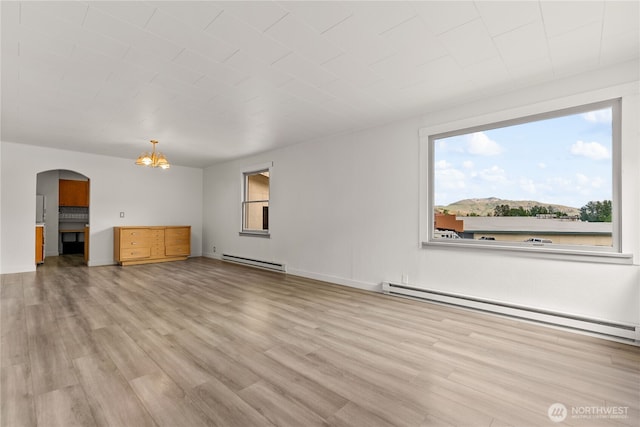 318 Lombard St, Twisp, WA 98856 - unfurnished living room with a baseboard heating unit, light wood finished floors, and arched walkways