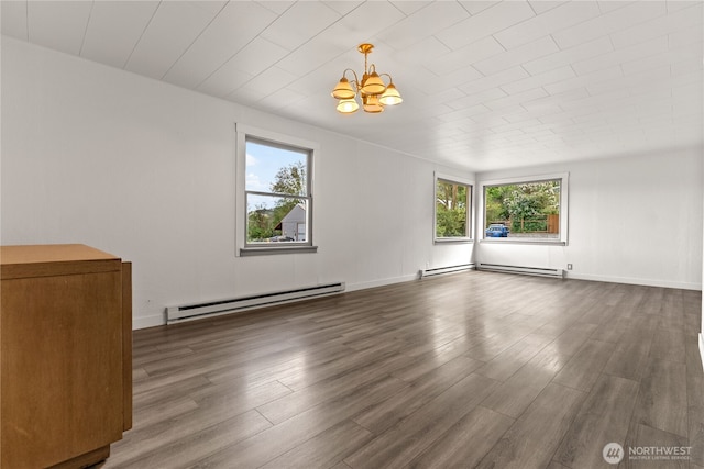 318 Lombard St, Twisp, WA 98856 - empty room with a baseboard heating unit, a chandelier, wood finished floors, a baseboard radiator, and baseboards