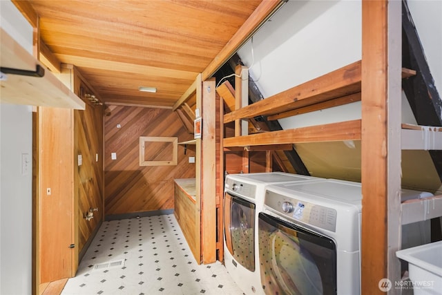 5617 236th Ave NE, Redmond, WA 98053 - washroom with washing machine and dryer, tile patterned floors, and wooden walls