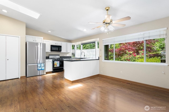 13219 SE 52nd Pl, Bellevue, WA 98006 - kitchen featuring range with gas stovetop, black microwave, freestanding refrigerator, dark countertops, and a sink