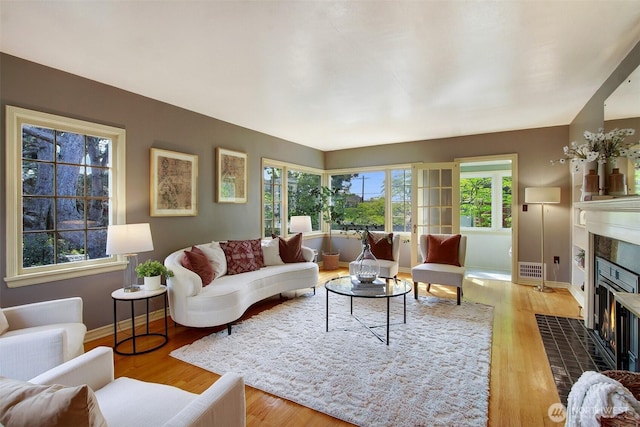 1635 46th Ave SW, Seattle, WA 98116 - living room featuring a fireplace, wood finished floors, and baseboards