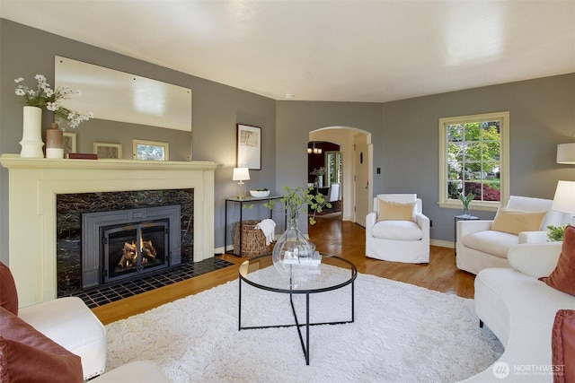 1635 46th Ave SW, Seattle, WA 98116 - living room with arched walkways, wood finished floors, a fireplace, and baseboards