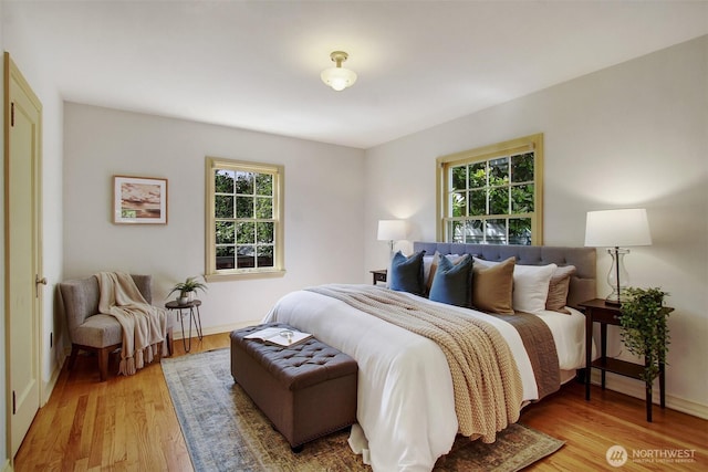 1635 46th Ave SW, Seattle, WA 98116 - bedroom featuring multiple windows, light wood finished floors, and baseboards