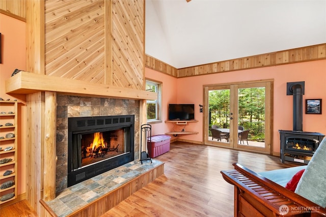 7480 Glacier Springs Dr, Deming, WA 98244 - living area with high vaulted ceiling, a wood stove, a fireplace, and wood finished floors