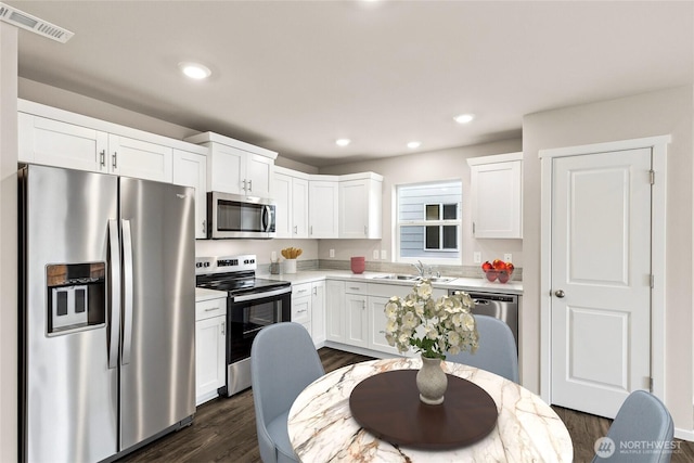 2967 Longhorn Loop Unit 275, Ellensburg, WA 98926 - kitchen with appliances with stainless steel finishes, a sink, light countertops, dark wood-style flooring, and white cabinetry