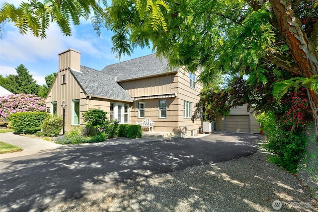 1701 W Yakima Ave, Yakima, WA 98902 - view of front of home featuring a chimney, a garage, a shingled roof, driveway, and board and batten siding