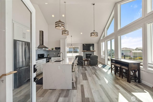 1438 Ocean Crest Ave SW, Ocean Shores, WA 98569 - kitchen with wall chimney range hood, freestanding refrigerator, a sink, gas range oven, and high vaulted ceiling