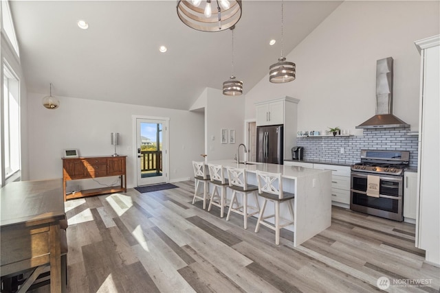 1438 Ocean Crest Ave SW, Ocean Shores, WA 98569 - kitchen with appliances with stainless steel finishes, wall chimney range hood, a kitchen breakfast bar, light countertops, and an island with sink