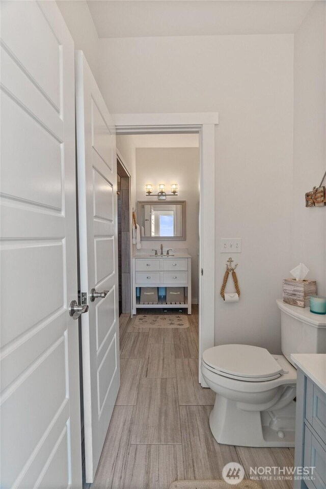 1438 Ocean Crest Ave SW, Ocean Shores, WA 98569 - bathroom featuring vanity, toilet, and wood finished floors